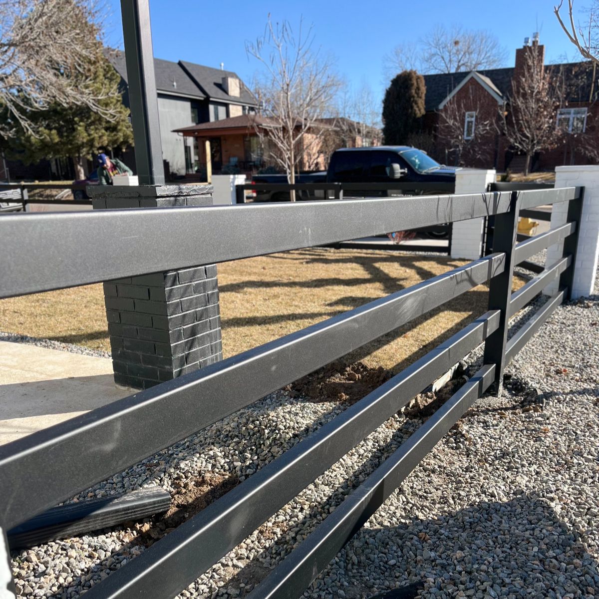 Custom steel fence with brick columns at a Denver front property line