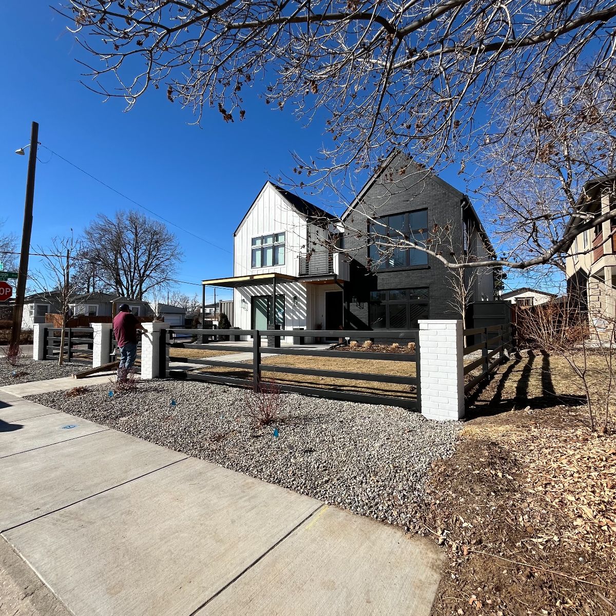 Custom black steel fence with brick masonry columns and gates in Denver CO